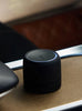 Black portable air freshner
 on a car tray with blurred outdoor background