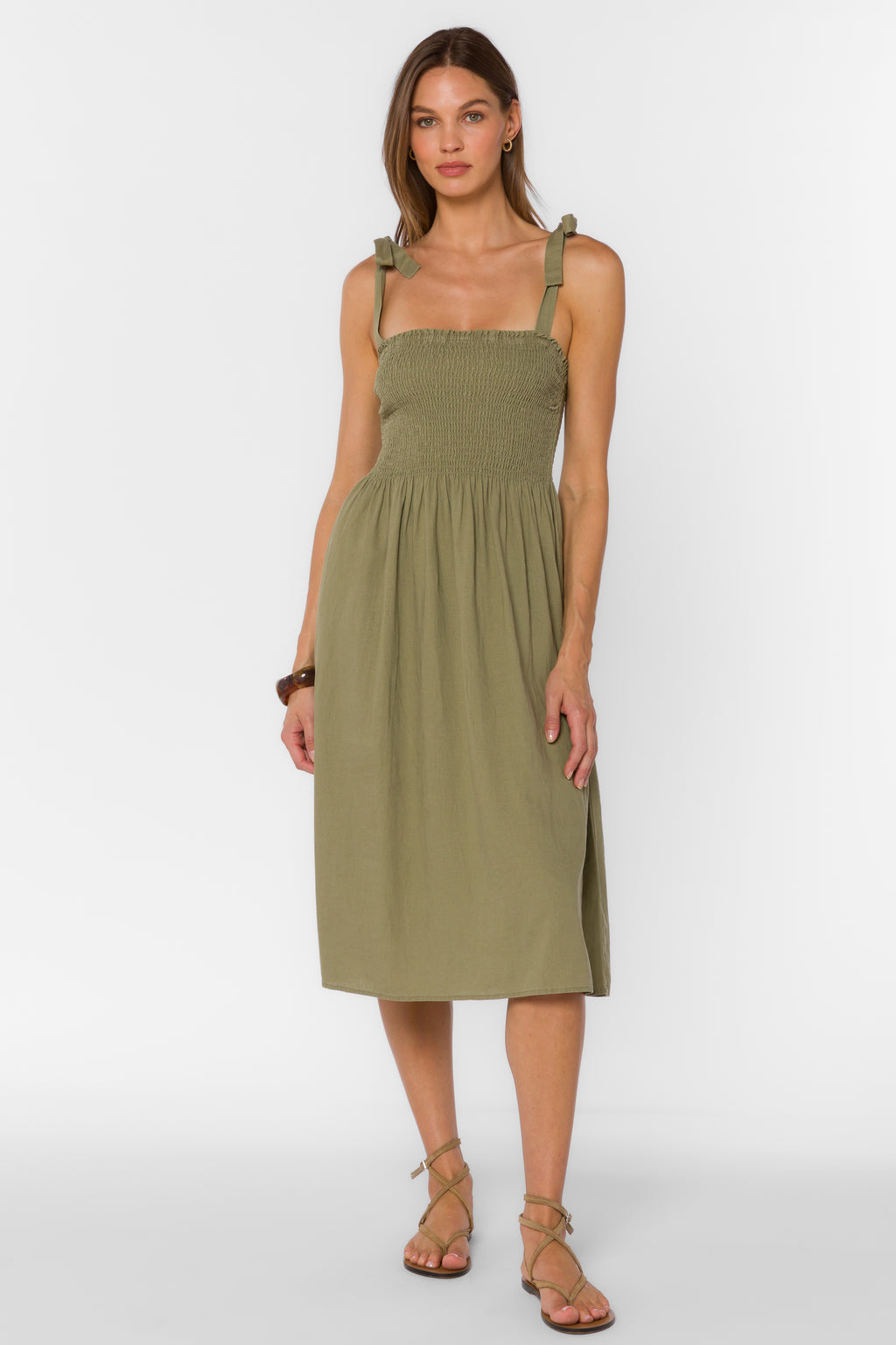 Woman wearing an olive green dress on a white background