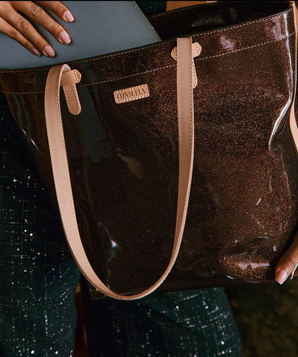 Brown glittery handbag with beige handle held by a person, brand 'CONSUELA' visible.